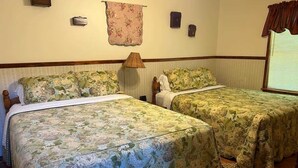 A room with two beds, each with floral bedding, a lamp, and a window with curtains. - Patoka Lake Deluxe with Jacuzzi #17 at Patoka 4 Seasons Resort (Eckerty)