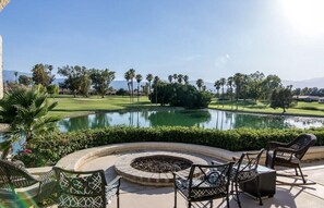 A patio area with outdoor seating, a circular fire pit, and a view of a golf course and mountains. - Renovated 2 bed 1.5 bath home w/ luscious green golf course views-Pet Friendly! (Palm Desert)