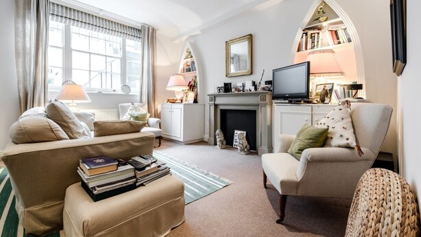 A cozy living room with a fireplace, comfortable seating, and a television. - 2 Bed 2 Bath Garden Flat in Victoria Pimlico (London)