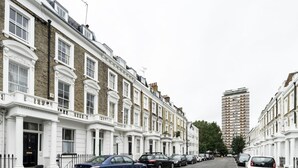 A row of terraced houses with a modern high-rise building in the background. - 2 Bed 2 Bath Garden Flat in Victoria Pimlico (London)