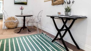 A room with a dining table, chairs, a rug, and framed pictures on the wall. - 2 Bed 2 Bath Garden Flat in Victoria Pimlico (London)