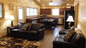 A cozy cabin interior with a living room, dining area, and kitchen.
