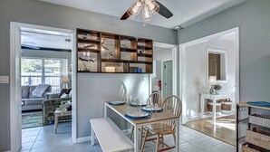 A dining area with a wooden table, chairs, and a ceiling fan. - Happy Gecko (Sarasota)