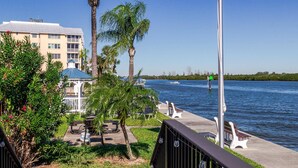 A waterfront view with a gazebo, benches, and a boat on the water. - Harbor Towers 4th Fl Modern 3BR With Den (Siesta Key)