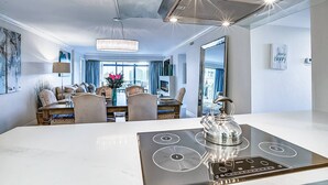 A modern kitchen with a central island, built-in oven, and a large window. - Harbor Towers 4th Fl Modern 3BR With Den (Siesta Key)