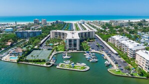 A marina with boats, a central building with multiple floors, and surrounding residential buildings. - Harbor Towers 2nd Fl 2 Bedroom Pool View (Siesta Key)