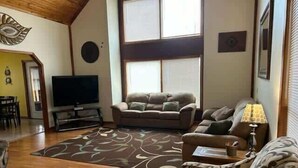 A living room with a sofa, a patterned rug, a television, and a lamp. - Patoka Lake Luxury Home #21 at Patoka 4 Seasons Resort (Eckerty)