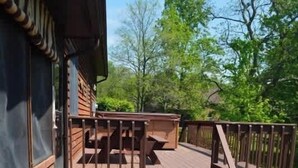 A wooden deck with two rocking chairs and a staircase leading to a covered area. - Patoka Lake Luxury Home #21 at Patoka 4 Seasons Resort (Eckerty)