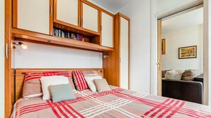 Ein Schlafzimmer mit einem Bett, einem Holzkopfteil, Bücherregalen und einem Bild an der Wand.