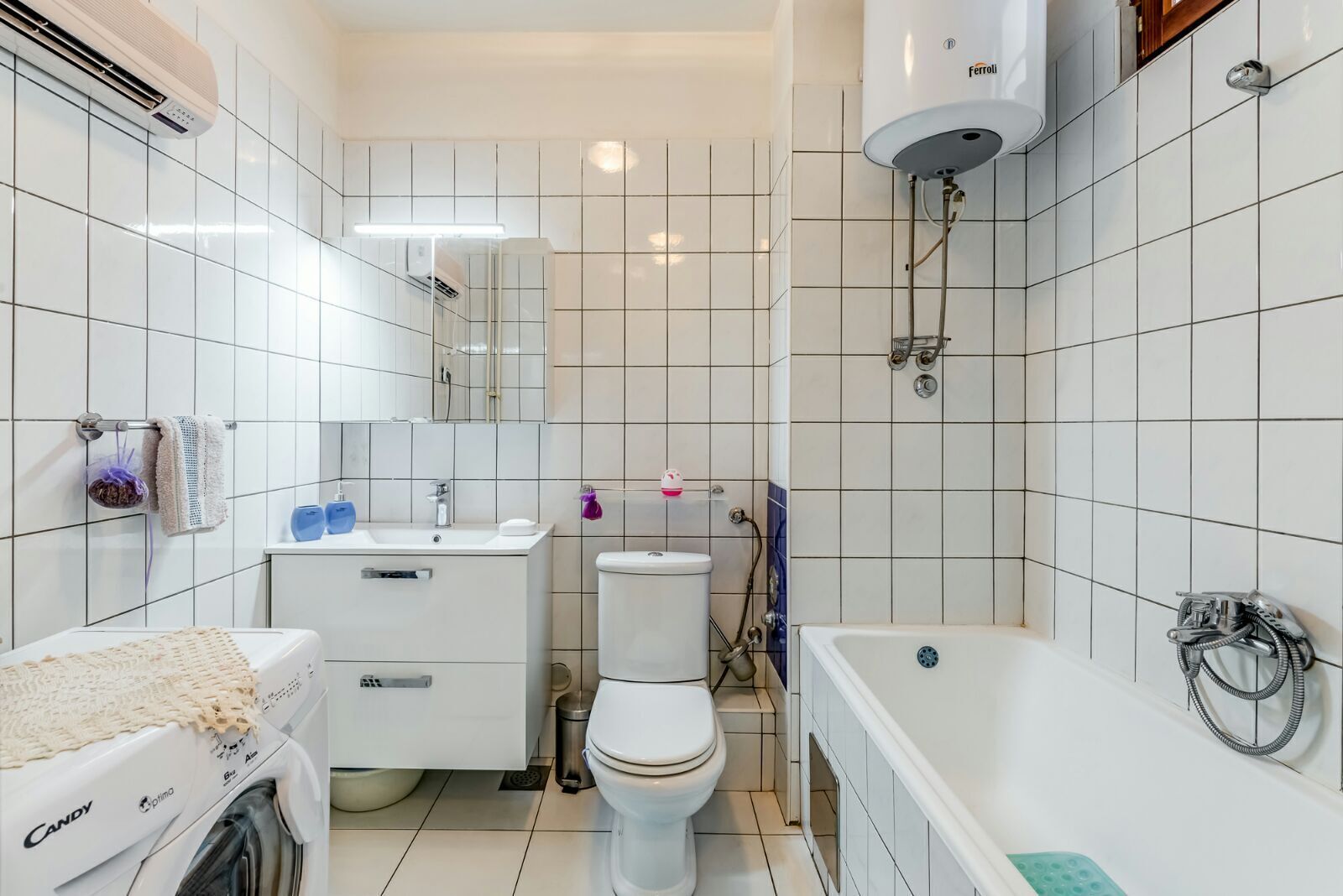 A bathroom with a washing machine, a toilet, a sink, and a bathtub.