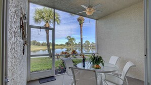 Ein Zimmer mit Seeblick, Deckenventilator und Tisch mit Stühlen.