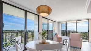 Un balcón amplio con una mesa redonda y sillas, un colgador de luces y vistas a la ciudad.