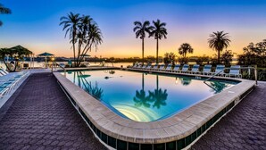 A swimming pool with lounge chairs and palm trees, surrounded by a paved walkway. - Palm Bay Club Bayside Closest to Gulf (Siesta Key)