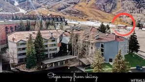 Un hôtel offrant une vue sur une station de ski, avec un bâtiment moderne et un télésiège visible au loin.