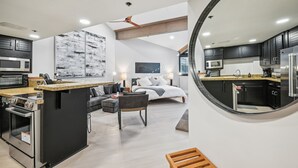 A modern kitchen with a central island, built-in appliances, and a dining area with a sofa and table.