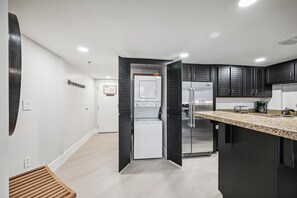 A modern kitchen with black cabinets, a stainless steel refrigerator, and a granite countertop. - Silver King Studio - Sleeps 4 - Walk to PC skiing (Park City)