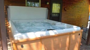 A hot tub in a wooden cabin with a window above it. - Patoka Lake Deluxe with Hot Tub #11 at Patoka 4 Seasons Resort (Eckerty)