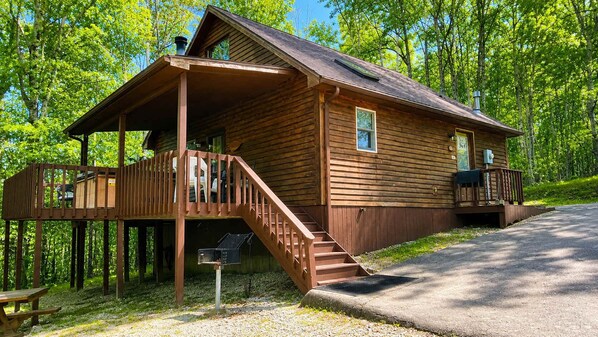Une cabane en bois avec une véranda, un escalier et une boîte aux lettres.