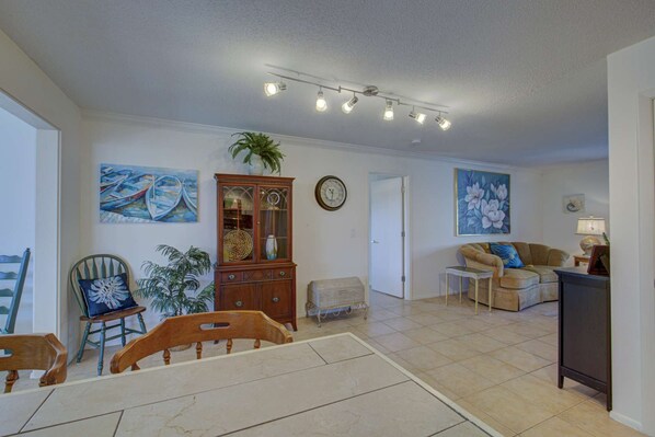 A spacious living room with a dining area, a wooden cabinet, and a sofa. - Peaceful Egret Pool Home in Venice (Venice)