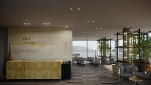 A modern reception area with a wooden reception desk, a wall-mounted sign reading "EALA my lakeside dream," and a view of the mountains through large windows. - Eala - My Lakeside Dream (Limone sul Garda)