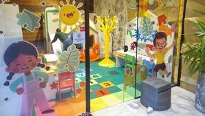 Een speelruimte voor kinderen met kleurrijke decoraties, een verbodsbord voor huisdieren en een speeltafel.