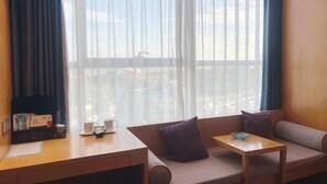 Una habitación con un escritorio de madera, un sofá acolchado y una mesita pequeña.