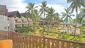 Un resort con varias edificaciones, un área de piscina con sombrillas y palmeras.