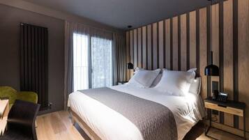 Habitació d'hotel moderna amb un llit gran, un escriptori i una cadira.