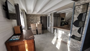 Una cucina moderna con schienale in pietra, elettrodomestici in acciaio inossidabile e un tavolo da pranzo in legno.