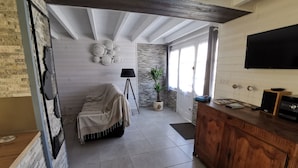 Una cucina moderna con un armadietto in legno, una TV nera e una pianta in vaso.