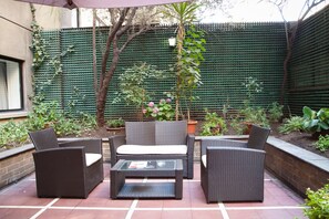 Relax and socialize in this serene patio area, featuring a sofa, armchairs, and a coffee table.