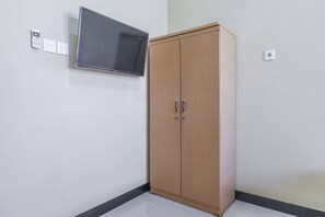 Ein Zimmer mit einem Holfischschrank, einem flachbildfernseher an der Wand und einer Steckdose.