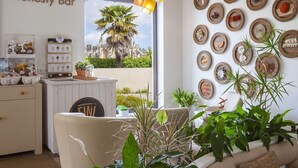 Un espace bar avec une pancarte indiquant « Bar à l’honneur », un comptoir avec un menu et une vue sur les palmiers à l’extérieur.