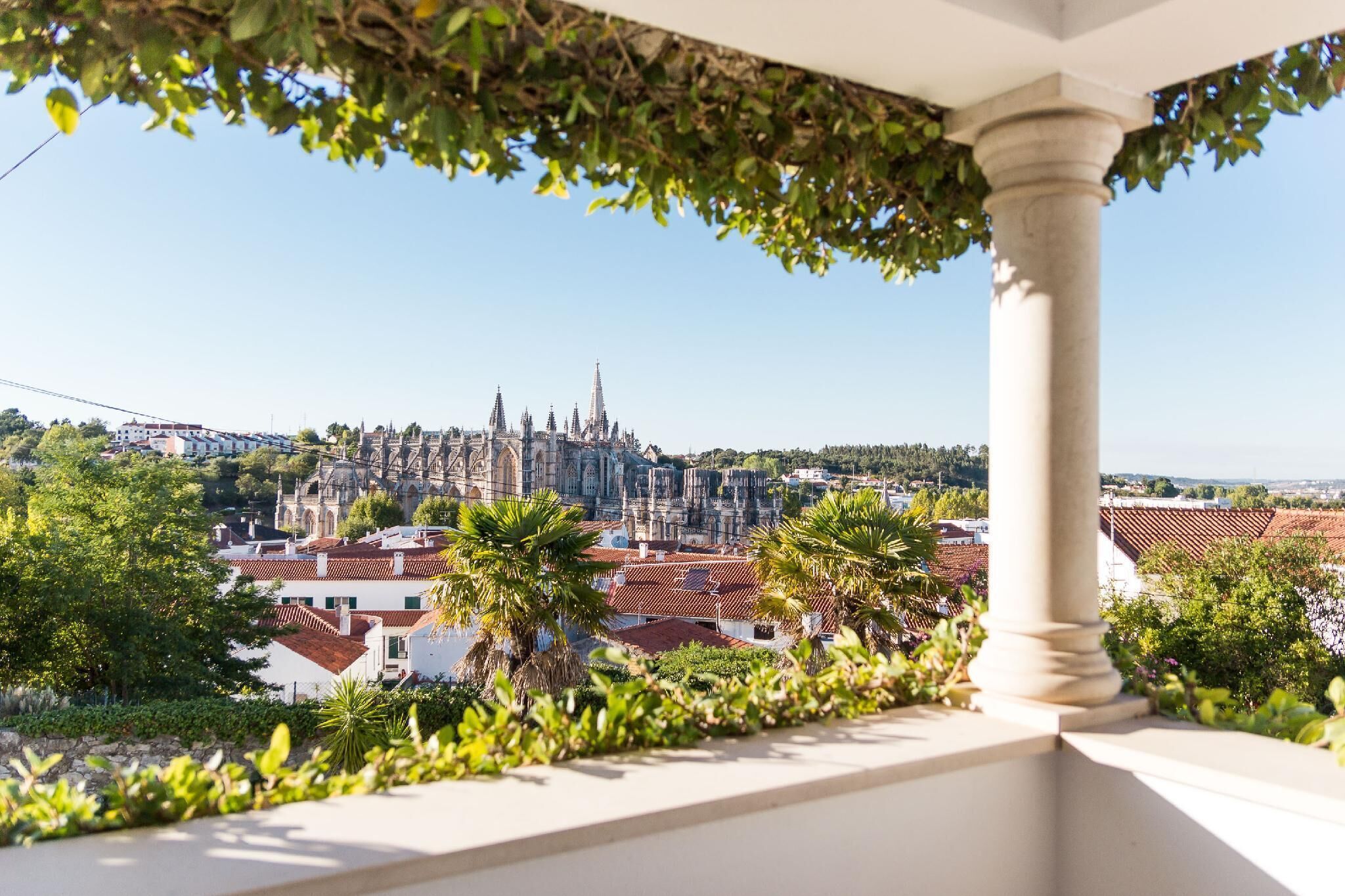 A balcony with a view of a historic cityscape, including a prominent cathedral and surrounding buildings.