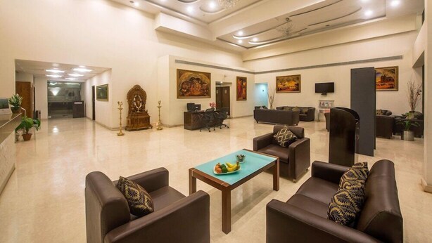 A spacious lobby with leather sofas, a reception desk, and artwork on the walls. - The Fern Residency Yeshwanthpur (Bengaluru)