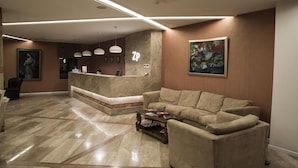 Un hall d’entrée moderne avec un comptoir d’accueil, un canapé et une table basse.