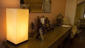 A room with a wooden desk, a lamp, a bookshelf, and a painting on the wall. - Sierra Madre (Quito)