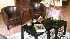 A living room with two leather armchairs, a coffee table with a book and a decorative item, and a small side table with a plant. - Garden (Viareggio)