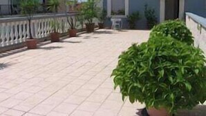 A terrace with potted plants and a railing. - Garden (Viareggio)
