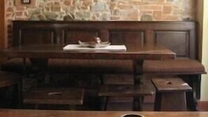 A rustic stone wall with a built-in bench and a small shelf above it. - Garden (Viareggio)