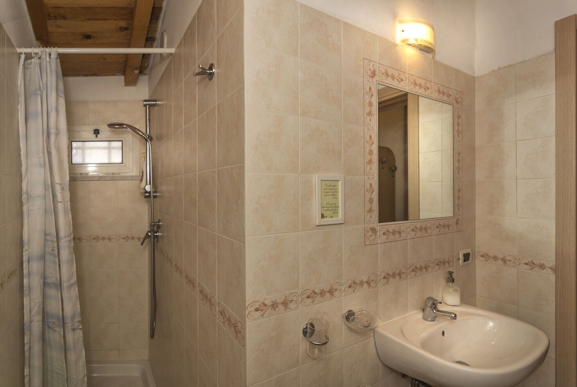 A bathroom with a shower, a sink, and a mirror.