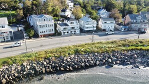 A coastal residential area with houses, a road, and a rocky shoreline. - The Blue Pearl (Nahant)