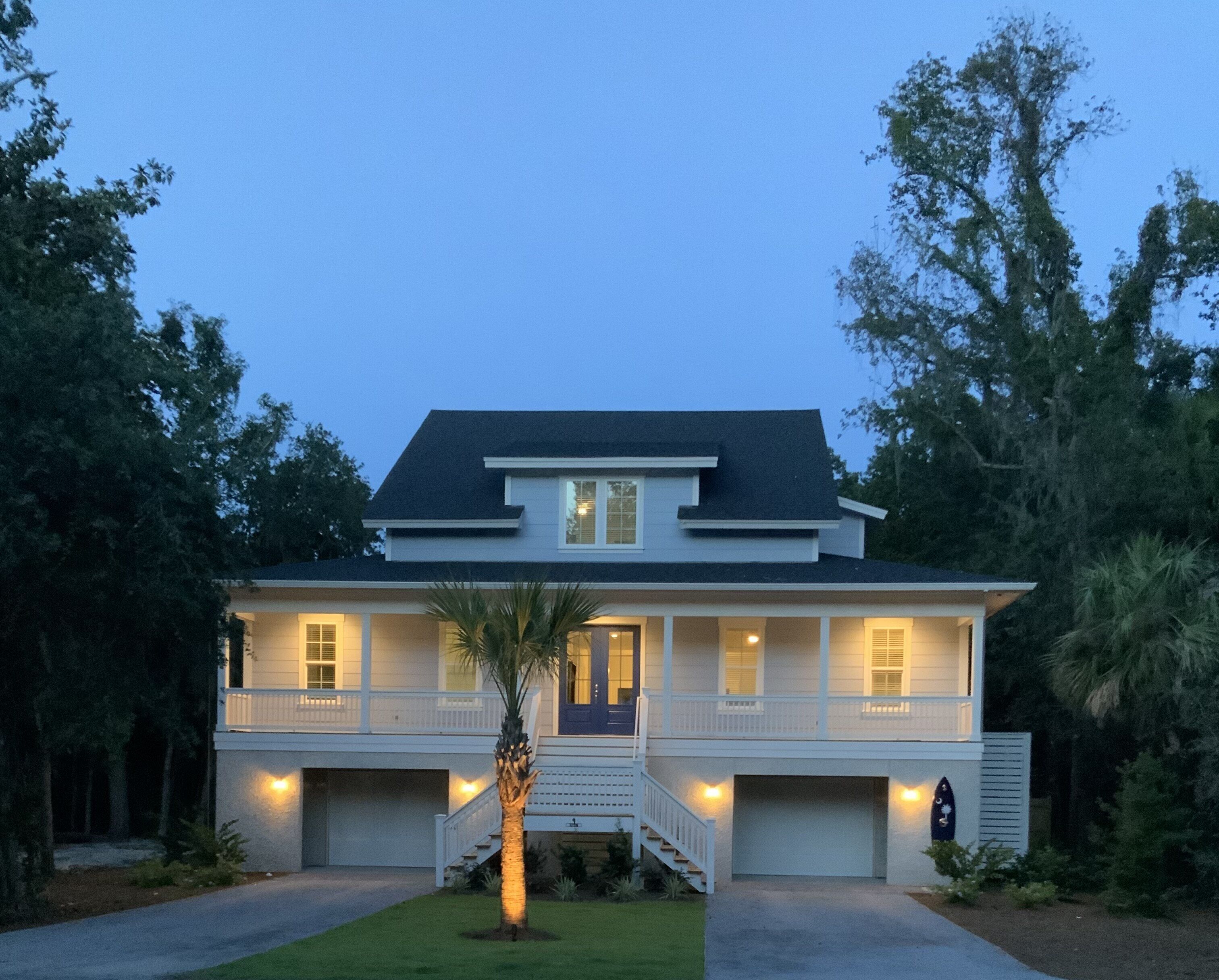 A two-story house with a front porch, a garage, and a well-maintained lawn.