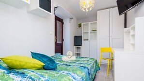 Un dormitorio moderno con cama, escritorio y armario.