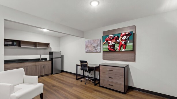 A modern kitchen with a white countertop, wooden cabinets, and a built-in microwave. - Red Roof Inn Del Rio (Del Rio)