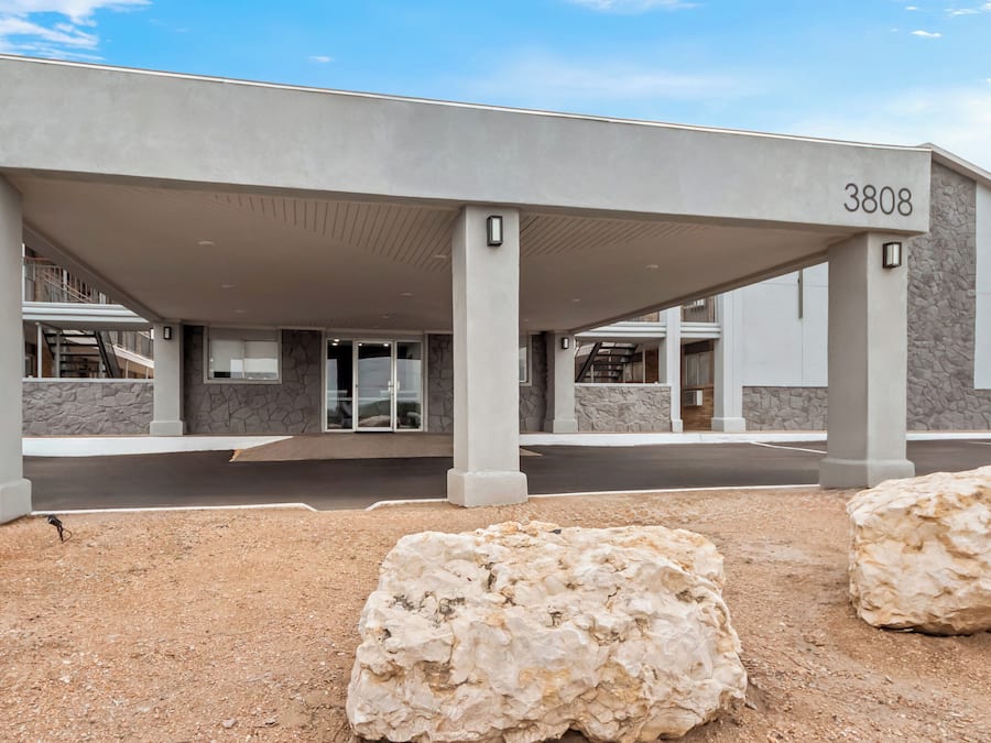 Un edificio moderno con entrada cubierta, número 3808, y fachada de piedra.