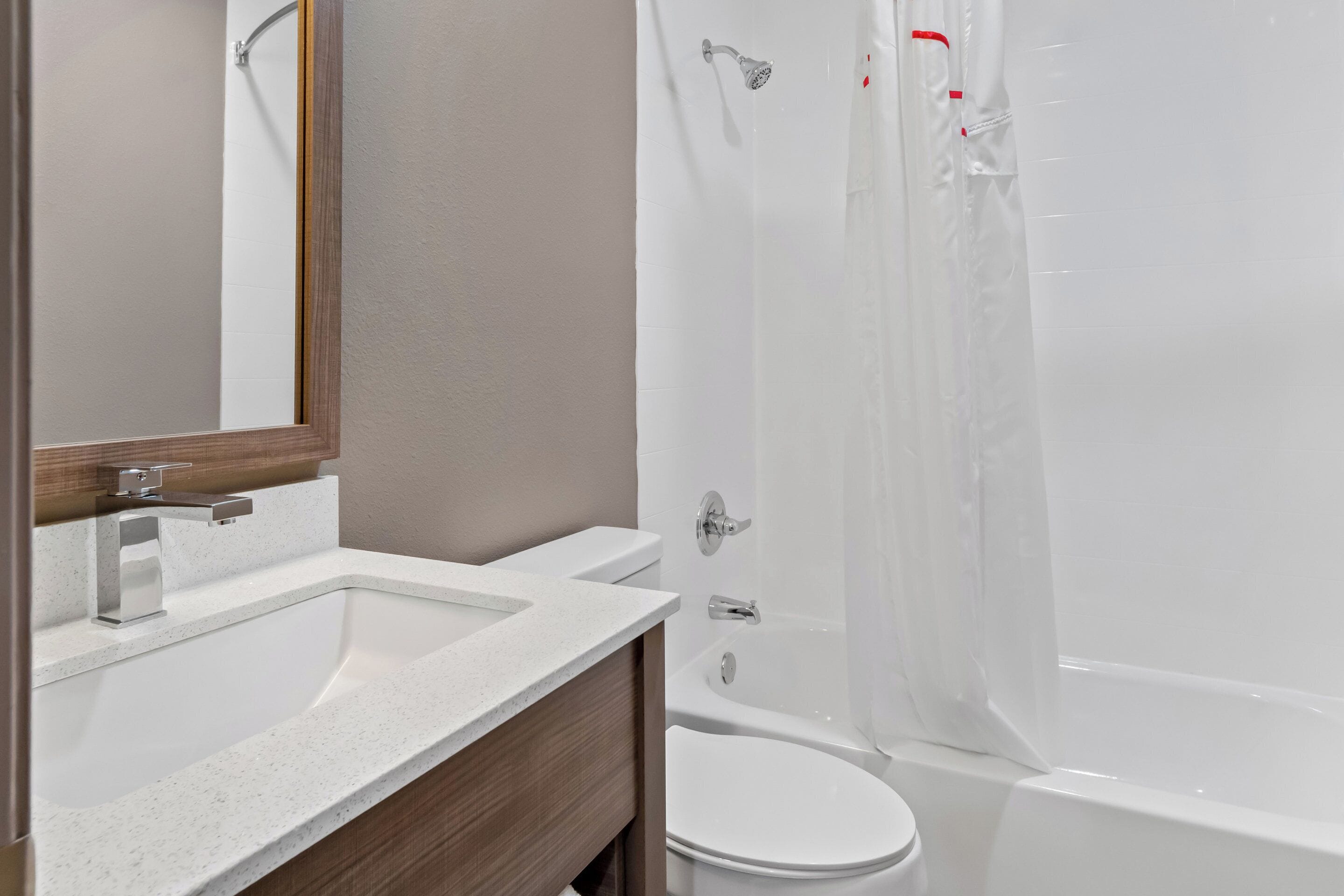 A bathroom with a white sink, a toilet, and a bathtub.