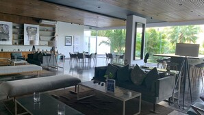 A modern lounge area with a sofa, coffee table, and dining area. - Exclusive apartment in Residencial Vía Montejo (merida)