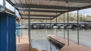 Ein überdachter Steg mit Booten und einem Holzdeck.