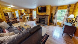 A cozy cabin interior with a living room, kitchen, and dining area.